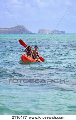 Hawaii, A young couple paddling their kayak. View Large Photo Image Stock Photo - Hawaii, A young couple paddling their kayak.. Fotosearch