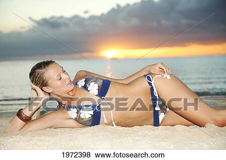 Hawaii, An Attractive Young Woman Lays In Sand On Beach. View Large Photo Image Stock Photo - Hawaii, An Attractive Young Woman Lays In Sand On Beach.. Fotosearch