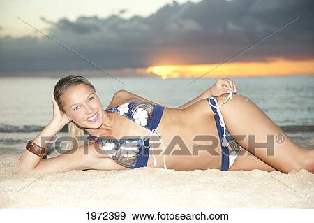Hawaii, An Attractive Young Woman Lays In Sand On Beach. View Large Photo Image Stock Photo - Hawaii, An Attractive Young Woman Lays In Sand On Beach.. Fotosearch