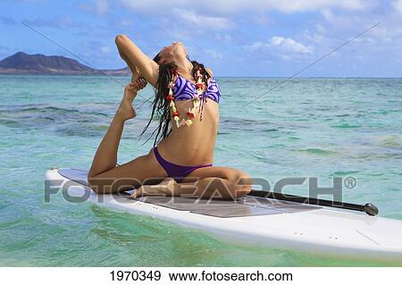 Stock Photo - Hawaii, Beautiful Brunette Girl Doing Yoga On Her Stand Up Paddle Board. Fotosearch