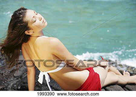 Hawaii, Beautiful Young Woman With Eyes Closed Relaxes On Rocky Ocean Shoreline View Large Photo Image Stock Image - Hawaii, Beautiful Young Woman With Eyes Closed Relaxes On Rocky Ocean Shoreline. Fotosearch