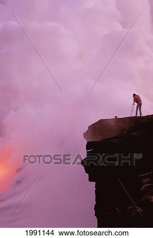 Picture - Hawaii, Big Island, Hawaii Volcanoes National Park, Photographer Taking Pictures Of Lava Eruption, Steam. Fotosearch