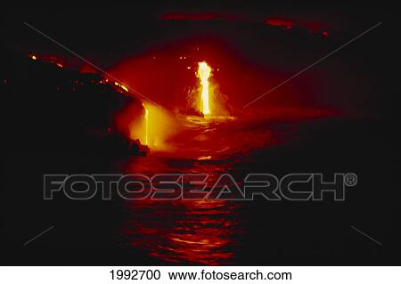 Stock Image - Hawaii, Big Island, Hawaii Volcanoes National Park, Lava Flows Into Ocean At Night, Bright Red Lava Reflecting On The Ocean.. Fotosearch