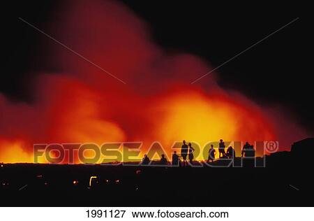 Stock Photo - Hawaii, Big Island, Hawaii Volcanoes National Park, Tourists Watch Lava Flow Into Ocean, Nighttime Glow. Fotosearch
