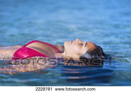 Stock Image - Hawaii, Big Island, Honaunau Bay, Beautiful Youn Woman Floating At Oceans Surface.. Fotosearch