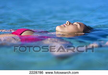 Stock Photograph - Hawaii, Big Island, Honaunau Bay, Beautiful Youn Woman Floating At Oceans Surface.. Fotosearch