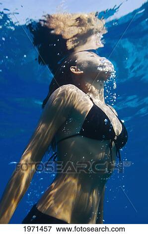 Stock Photo - Hawaii, Big Island, Honaunau Bay, Young Woman Exhales As She Swims To Ocean Surface.. Fotosearch