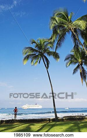 Hawaii, Big Island, Kailua-Kona, Luxury Cruise Ship Pride Of Aloha Woman Stands At Hale Halewai Park Watching It Pass, Palm Trees Overhead. View Large Photo Image Stock Photo - Hawaii, Big Island, Kailua-Kona, Luxury Cruise Ship Pride Of Aloha Woman Stands At Hale Halewai Park Watching It Pass, Palm Trees Overhead.. Fotosearch