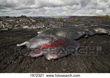 Stock Image - Hawaii, Big Island, Kalapana, Pahoehoe Lava Flowing From Kilauea Covering An Older Pahoehoe Flow.. Fotosearch