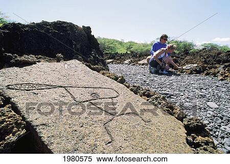 Stock Photography - Hawaii, Big Island, Kohala Coast, Mauna Lani Resort, Couple Observing Stones At Petroglyph Park.. Fotosearch