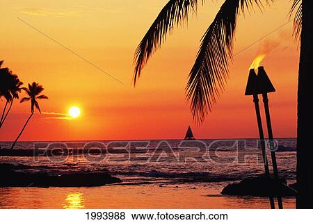 Stock Photo - Hawaii, Big Island, Kohala, Waiulua Bay, Orange Sunset With Palm Trees, Sailboat And Tiki Torches.. Fotosearch
