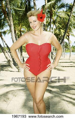 Stock Image - Hawaii, Big Island, Kona, Beautiful Woman On Beach Wearing Red Swimsuit.. Fotosearch