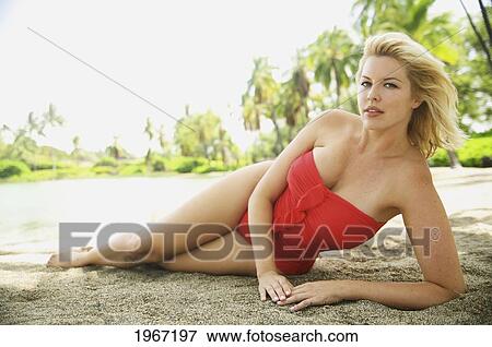 Hawaii, Big Island, Kona, Beautiful Woman Lounging Along Beach Wearing Red Swimsuit. View Large Photo Image Stock Photo - Hawaii, Big Island, Kona, Beautiful Woman Lounging Along Beach Wearing Red Swimsuit.. Fotosearch