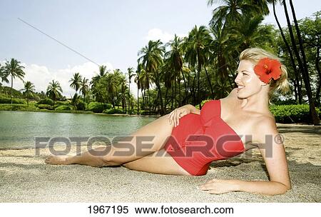 Hawaii, Big Island, Kona, Beautiful Woman Lounging Along Beach Wearing Red Swimsuit. View Large Photo Image Stock Photography - Hawaii, Big Island, Kona, Beautiful Woman Lounging Along Beach Wearing Red Swimsuit.. Fotosearch