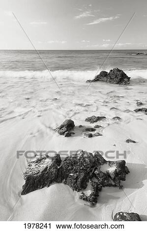Stock Image - Hawaii, Big Island, Kona Coast, Makalawena Beach, Ocean Washing Over Rocks (Sepia Photograph).. Fotosearch