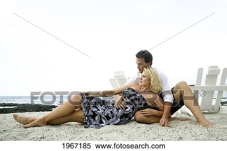 Stock Photography - Hawaii, Big Island, Kona, Couple Lounging On Beach.. Fotosearch