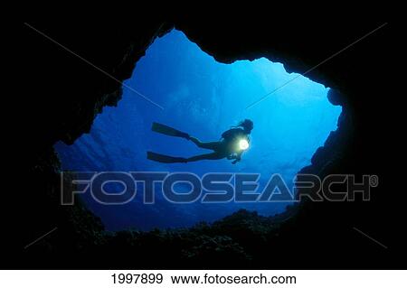 Stock Photo - Hawaii, Big Island, Kona, Diver At Cavern Entrance With Flash Light, Silhouette A81E. Fotosearch