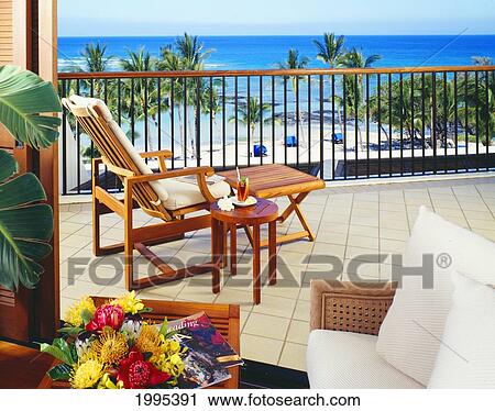 Stock Image - Hawaii, Big Island, Mauna Lani Resort, Lounge Chair On A Lanai Overlooking The Beach.. Fotosearch