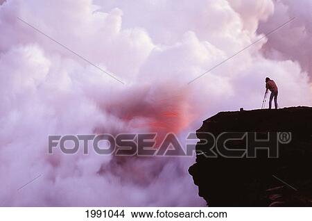 Picture - Hawaii, Big Island, Photographer On Lava Table Filming Lava Flow Into Ocean. Fotosearch