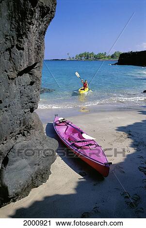 Stock Image - Hawaii, Big Island, Pink Kayak On Shore Woman In Yellow Kayak Near Shore. Fotosearch