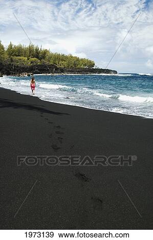 Stock Photo - Hawaii, Big Island, Pololu Valley Black Sand Beach, Woman Standing In The Shorebreak.. Fotosearch