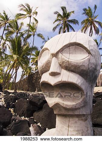 Stock Image - Hawaii, Big Island, Puuhonua O Honaunau, City Of Refuge, Ki'i Against Blue Sky And Palm Trees.. Fotosearch