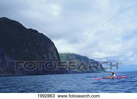 Stock Image - Hawaii, Big Island, View Of Kayaker Off The North Shore, Blue Water And Sky. For Editorial Use Only.. Fotosearch