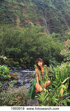 Hawaii, Big Island, Waipio Valley, Wahine Wearing Ti-Leaf Lei And Skirt Amid Rainforest And Waterfalls. View Large Photo Image Stock Photo - Hawaii, Big Island, Waipio Valley, Wahine Wearing Ti-Leaf Lei And Skirt Amid Rainforest And Waterfalls.. Fotosearch