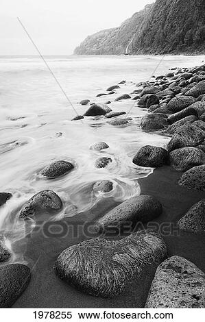 Hawaii, Big Island, Waipio Valley, Black Sand Beach With Mossy Rocks And Swirling Water (Black And White Photograph). View Large Photo Image Stock Photography - Hawaii, Big Island, Waipio Valley, Black Sand Beach With Mossy Rocks And Swirling Water (Black And White Photograph).. Fotosearch