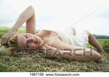 Stock Photo - Hawaii, Big Island, Woman Lying On Country Hillside.. Fotosearch