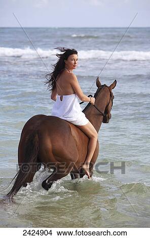 Hawaii, Brunette woman horseback riding in ocean. View Large Photo Image Picture - Hawaii, Brunette woman horseback riding in ocean.. Fotosearch