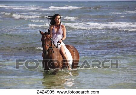 Hawaii, Brunette woman horseback riding in ocean. View Large Photo Image Stock Photography - Hawaii, Brunette woman horseback riding in ocean.. Fotosearch