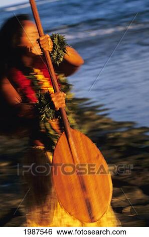 Stock Photograph - Hawaii, Close-Up Of Hula Girl Holding Wooden Paddle, Blurred Background.. Fotosearch