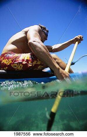 Stock Photograph - Hawaii, Close-Up Of Man Paddling In One Man Canoe, Over/Under View Of Paddle Stroking Water.. Fotosearch