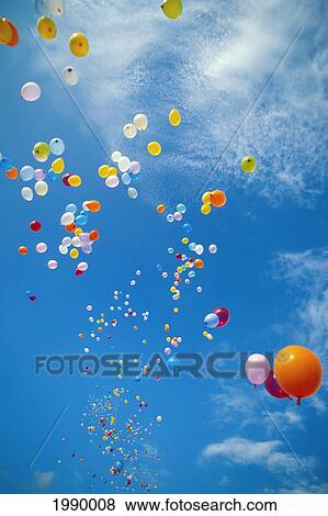 Stock Photo - Hawaii, Colorful Balloons Float In The Air Against A Blue Sky With White Clouds. Fotosearch