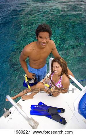 Stock Photo - Hawaii, Couple With Snorkel Gear On A Boat Over Reef.. Fotosearch