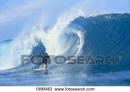 Stock Image - Hawaii, Derek Ho Standing On Board, Looks At Camera In Front Of Curling Wave. Fotosearch