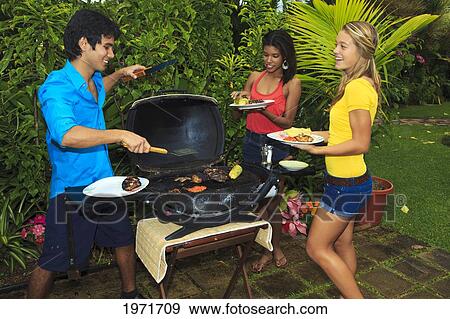 Hawaii, Friends Having Outdoor Barbecue In Tropical Garden. View Large Photo Image Stock Photo - Hawaii, Friends Having Outdoor Barbecue In Tropical Garden.. Fotosearch