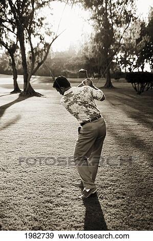 Hawaii, Golfer About To Swing Showing Form. Dramatic Light. View Large Photo Image Stock Photo - Hawaii, Golfer About To Swing Showing Form. Dramatic Light.. Fotosearch