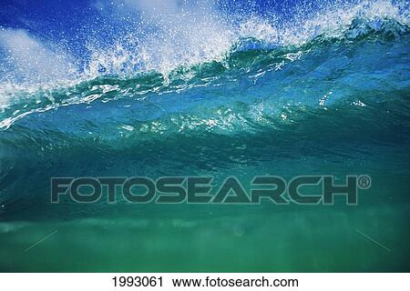 Stock Image - Hawaii, Green Wave At It's Peak With White Wash, Blue Sky. Fotosearch