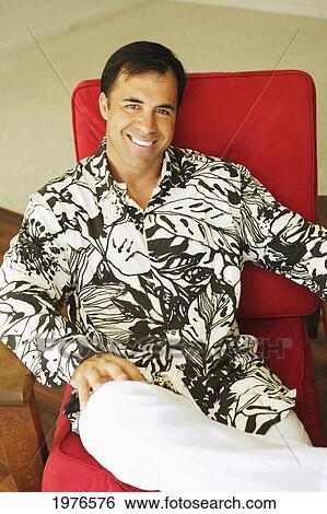 Stock Photograph - Hawaii, Handsome Man Sitting On Red Lounge Chair.. Fotosearch