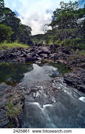 Stock Image - Hawaii, Hilo, Rainwater flows through Boiling Pots Park.. Fotosearch