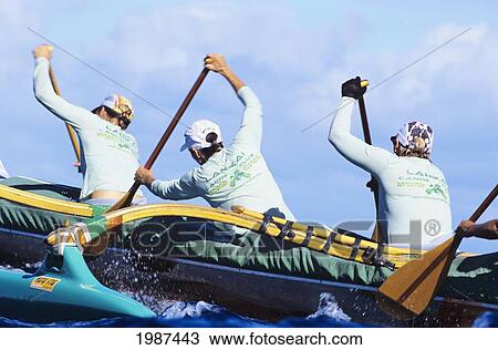 Stock Image - Hawaii, Kaiwi Channel, Molokai To Oahu, Women Paddling In Na Wahine O Kekai Race, Reaching High With Paddles. No Model Release. Fotosearch