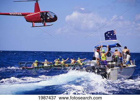 Stock Photo - Hawaii, Kaiwi Channel, Molokai To Oahu, Female Paddlers In The Na Wahine O Kekai Race With Helicopter And Escort Boat. No Model Release. Fotosearch