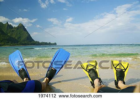 Stock Image - Hawaii, Kauai, A Couple Wearing Yellow And Blue Fins On Beach.. Fotosearch