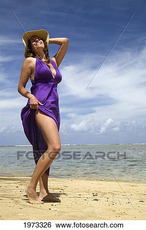 Stock Photograph - Hawaii, Kauai, Anini Bay, Woman Walking The Beach With A Purple Dress On.. Fotosearch