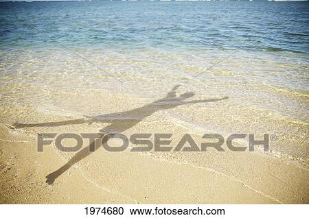 Stock Image - Hawaii, Kauai, Anini Beach, Shadow Of A Person In The Water.. Fotosearch