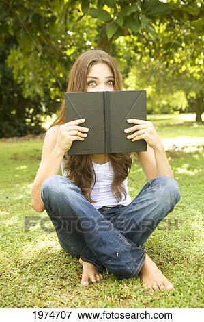 Stock Photo - Hawaii, Kauai, Attractive Young Woman In The Park Reading A Book.. Fotosearch