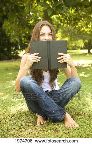 Stock Photograph - Hawaii, Kauai, Attractive Young Woman In The Park Reading A Book.. Fotosearch