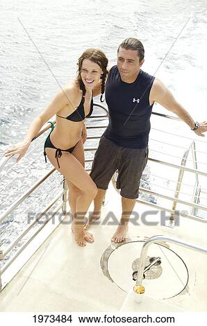 Picture - Hawaii, Kauai, Couple Stands On The Rail Of A Boat.. Fotosearch